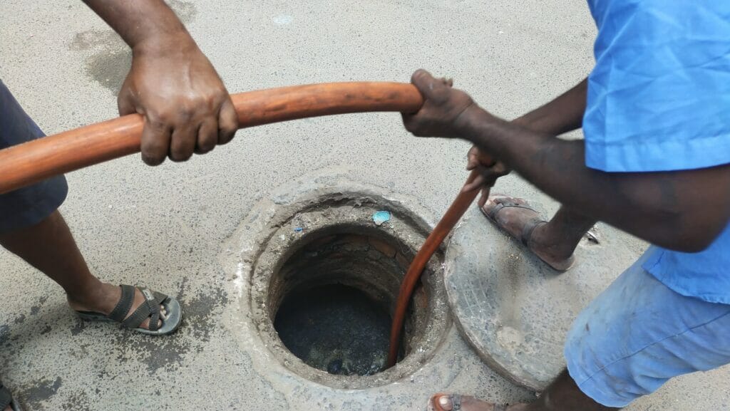Manual workers in Chennai clearing the blocks in manholes using a jet-rodding machine