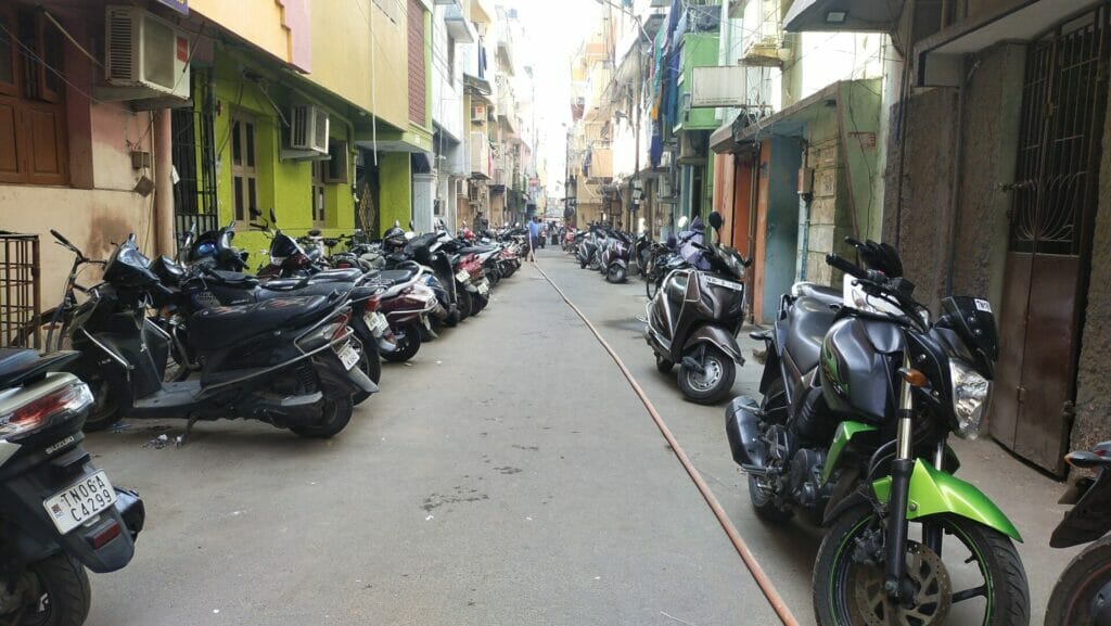 Vehicles parked on either side of the narrow streets in Chennai