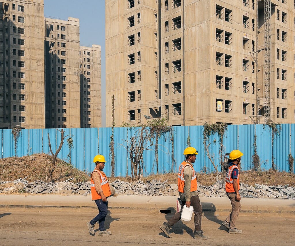 Construction workers walking in front of a vacant building