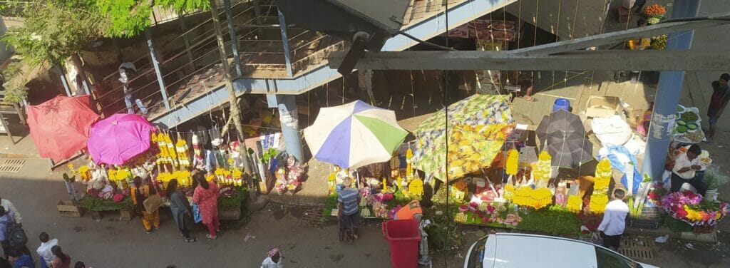 hawkers selling flowers right next to a foot over bridge 