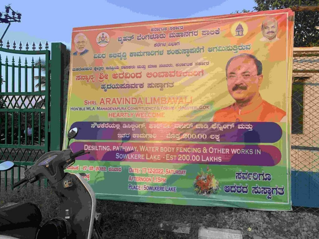 A flex banner with the BBMP logo declaring that ₹200 lakh (₹2 crores) has been sanctioned for public works such as "desilting, pathway, water body fencing and other works". 