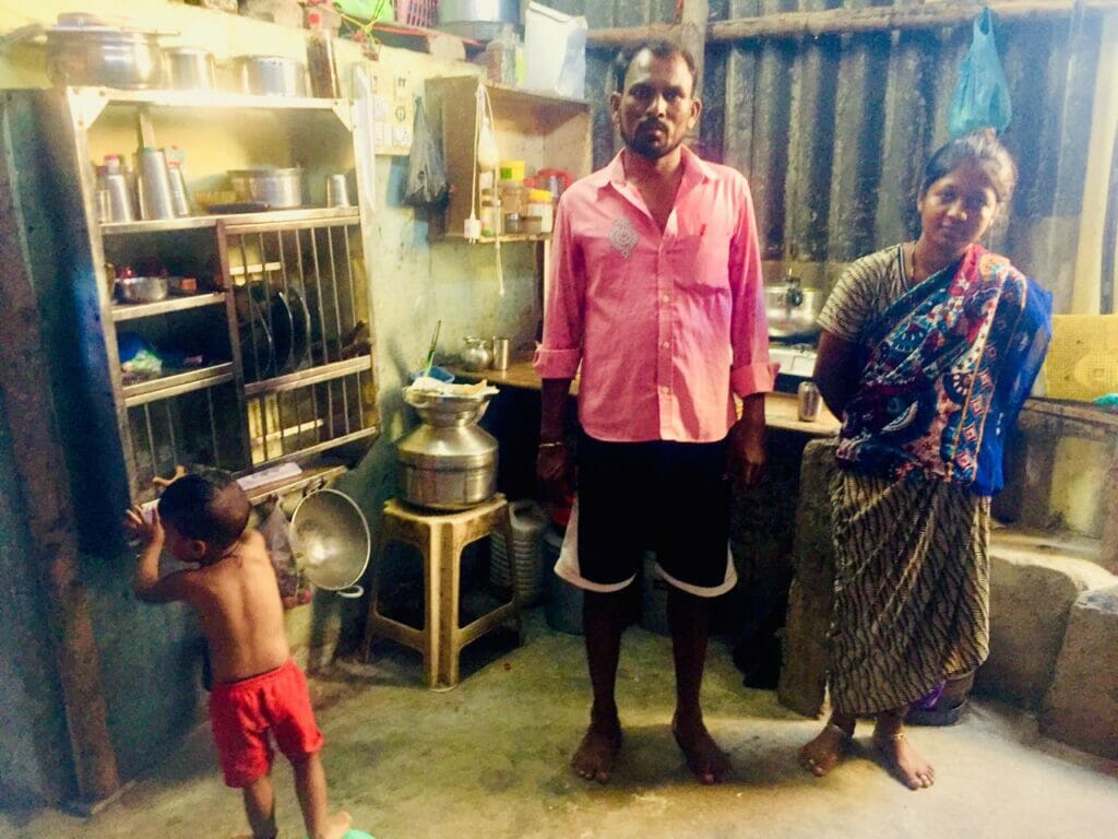 A pardhi couple with their young child in a small house in Ambujwadi. 