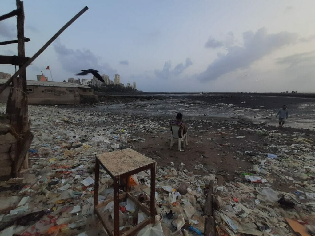view of chimbai beach with garbage littered everywhere