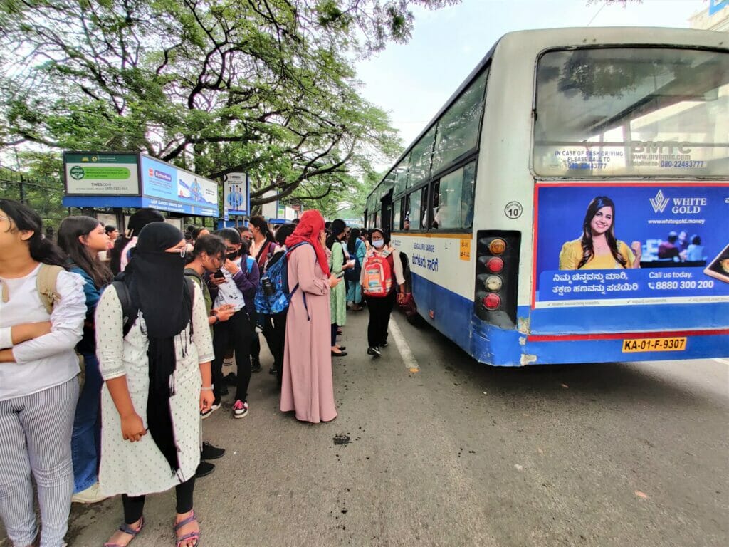 Women commuters waiting at a bus stop in Bengaluru
