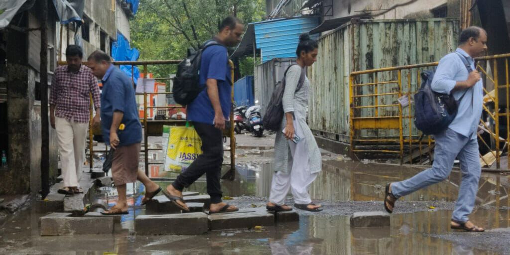 People have put blocks to walk on to navigate the flooded street next to Kanjur Marg Station. 