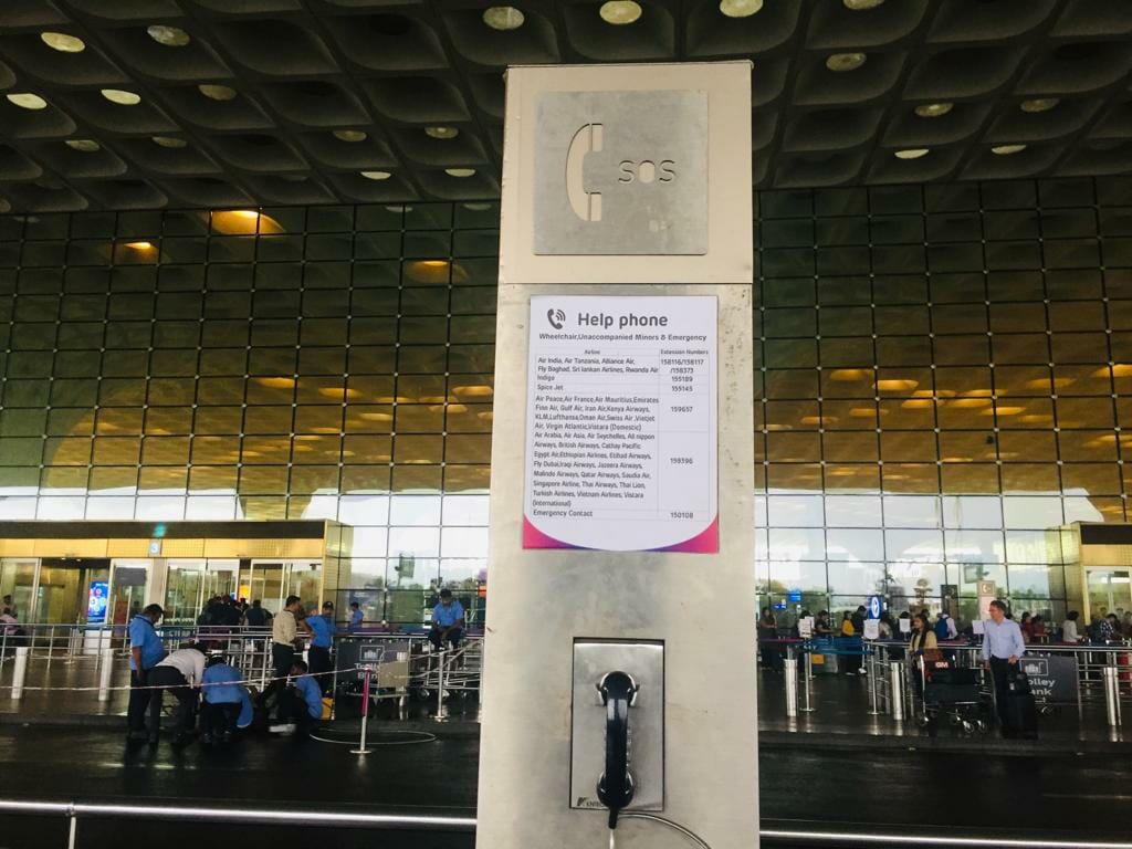 helpline numbers displayed at airport with a phone 