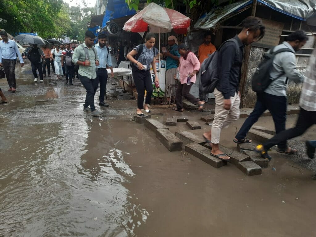 People find it difficult to walk due waterlogging outside the Kanjurmarg station.