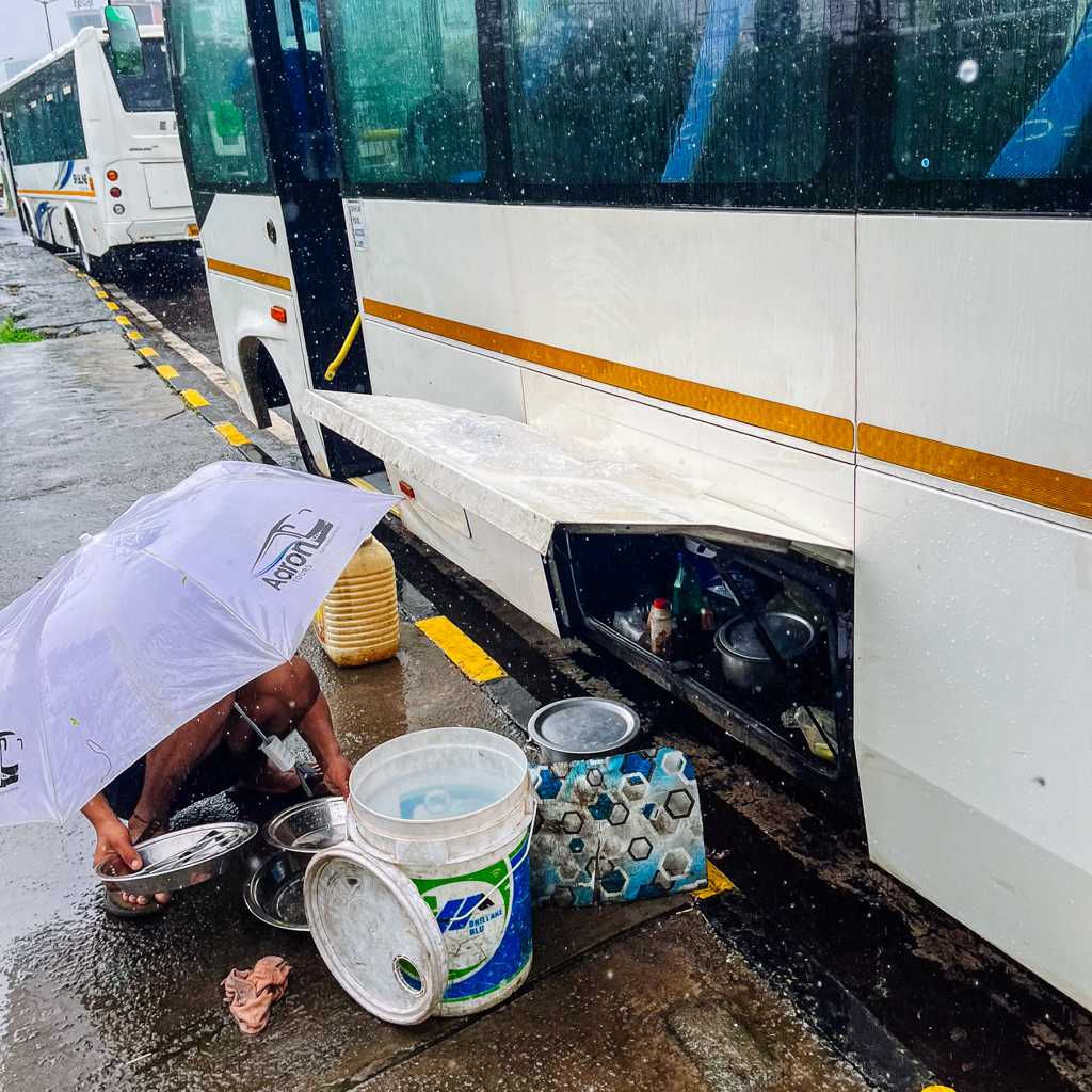 A driver of a bus commute app cooks his food outside his home - the bus he drives all day.