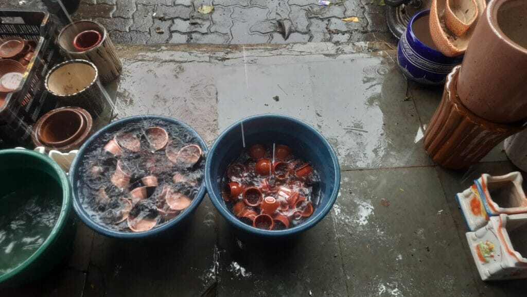 rain water falling over pots in buckets in kumbharwada, dharavi 
