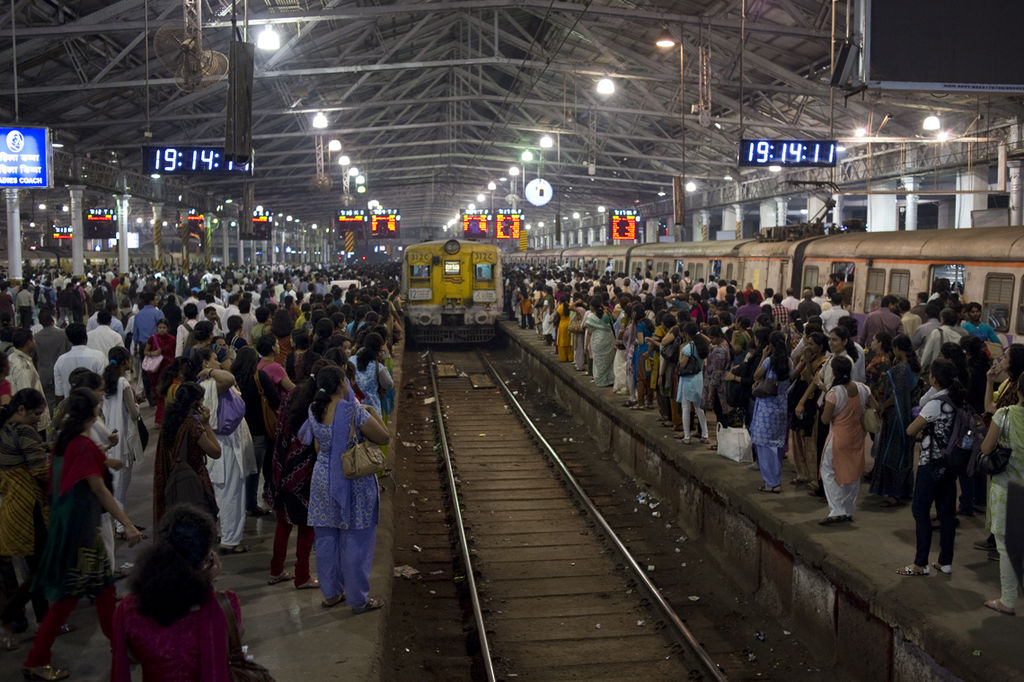 crowded station as a train approaches on the platform
