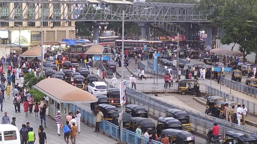 Peak traffic time at Bandra station with autos, share autos and buses 