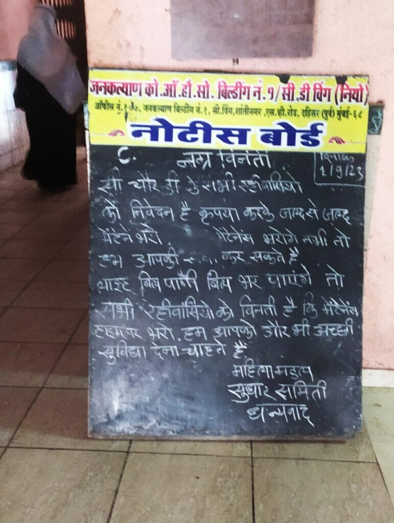 A blackboard asking residents to clear their pending maintenance charges. 