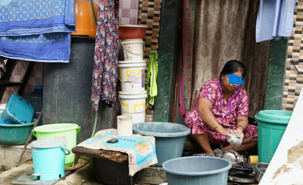 woman washing vessels outside home