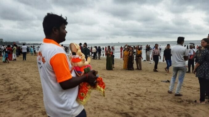 A Juhu Beach Lifeguard volunteer helping people to immerse their idols. Pic: Stephin Thomas