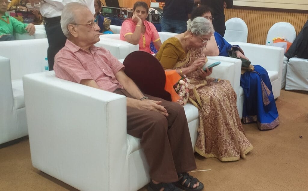 elderly woman looking at her smart phone at a seminar for senior citizens