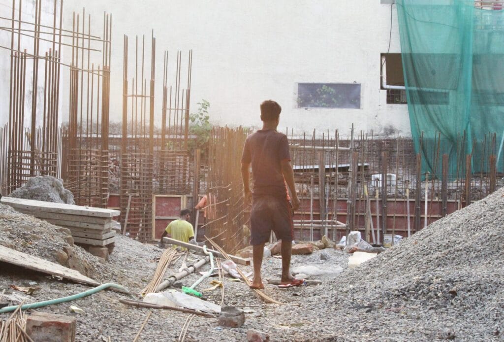 A man in a construction site, amid the visible dust and pollution