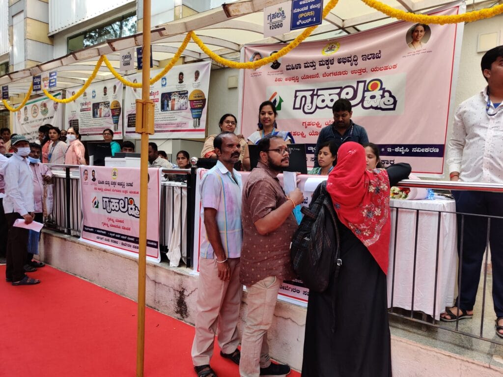 People standing in front of at the Gruha Lakshmi helpdesk