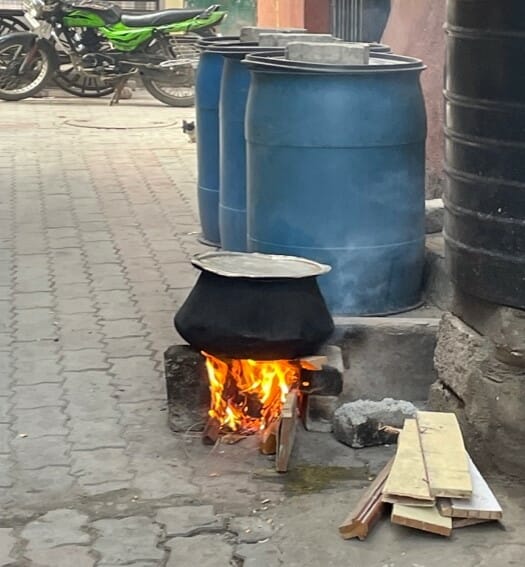 Cooking being done in a small makeshift stove outdoors in a Bengaluru slum.