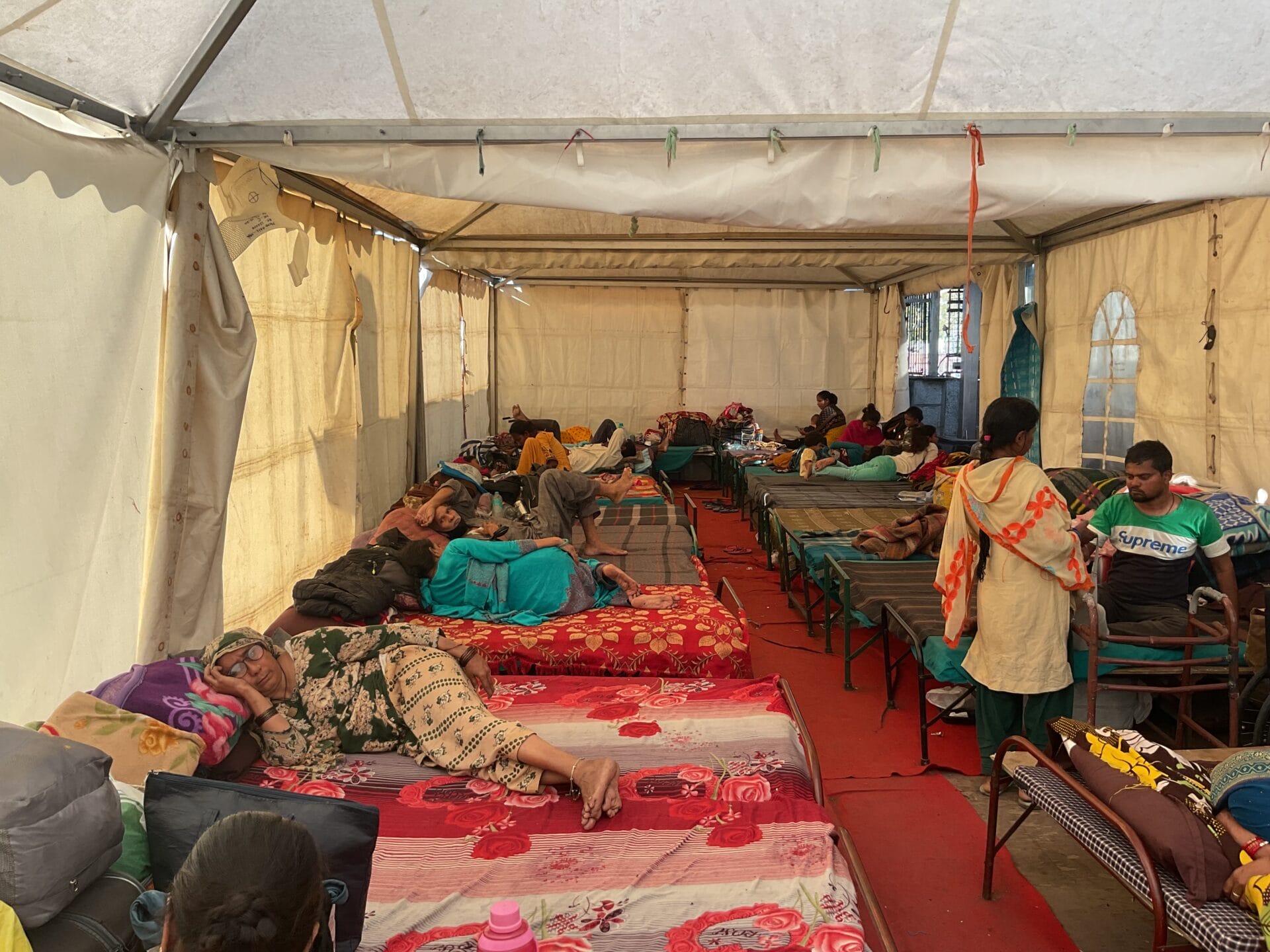 Beds and people inside the shelter near AIIMS Metro station