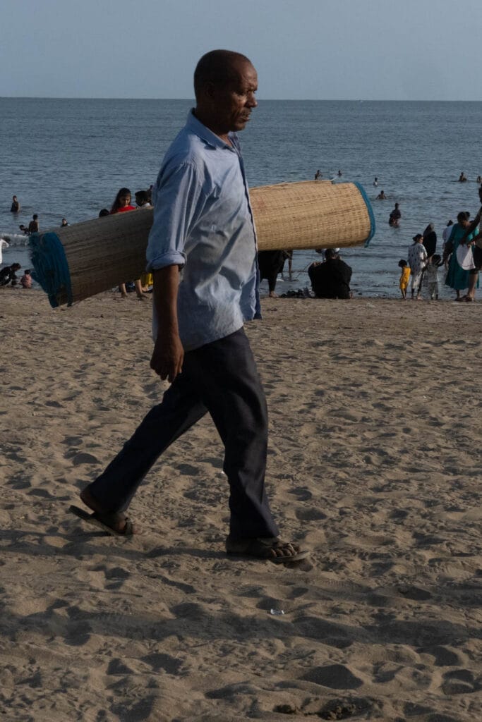 Man selling mats on the beach